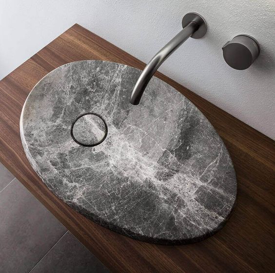 a fantastic oval stone modern sink to make a statement in a bathroom