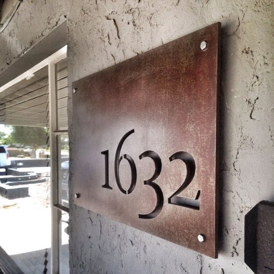 an aged metal house number with cutout numbers is a stylish idea for a mid-century modern house