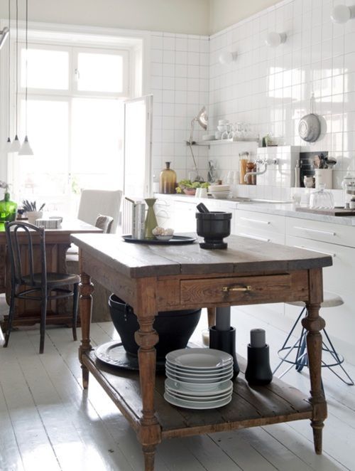 a vintage rustic kitchen island with much storage in a neutral and modern kitchen