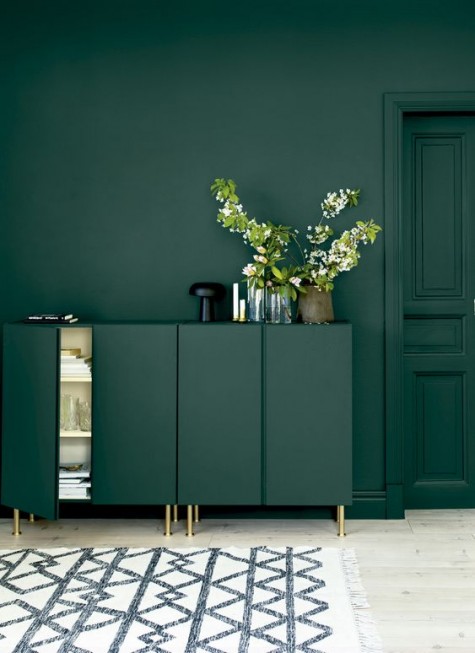 dark green Ivar cabinets with gold legs in front of a matching wall create a gorgeous moody space