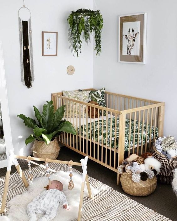a boho nursery with potted greenery, macrame, wicker baskets and a printed rug