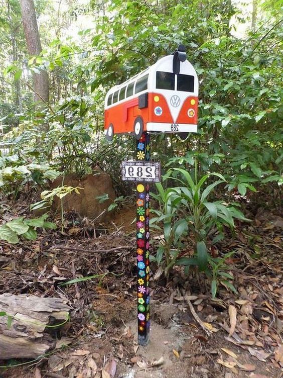a fun mid-century modern van mailbox on a wooden stand decorated with painted flowers is a cool boho chic idea