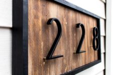 18 a modern house number sign with wood shims and black metal numbers and frame looks stylish and very laconic