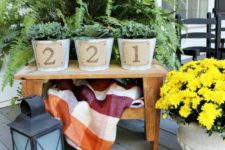19 a front porch with a table and planters on them, plant something and add burlap house numbers on it for a rustic feel