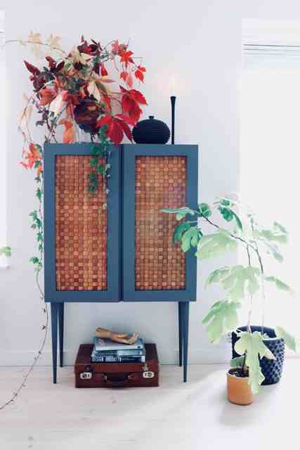 an IKEA Ivar cabinet painted blue, placed on tall legs and clad with corks is a bold and very whimsical idea