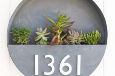 20 a brushed metal round wlal planter with numbers and succulents in it is a chic idea with a mid-century modern feel