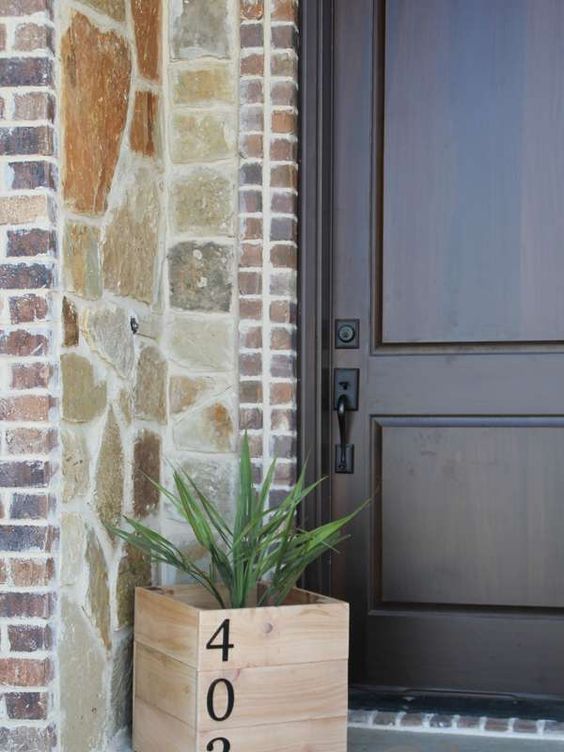 a wooden planter with some greenery and table numbers on them is a simple and fast DIY project for any porch