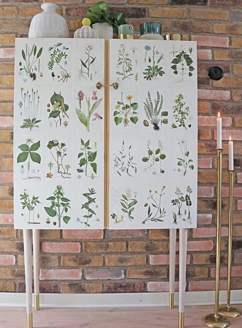 an IKEA Ivar cabinet placed on tall legs and decorated with vintage plant pictures is a whimsy hack to try