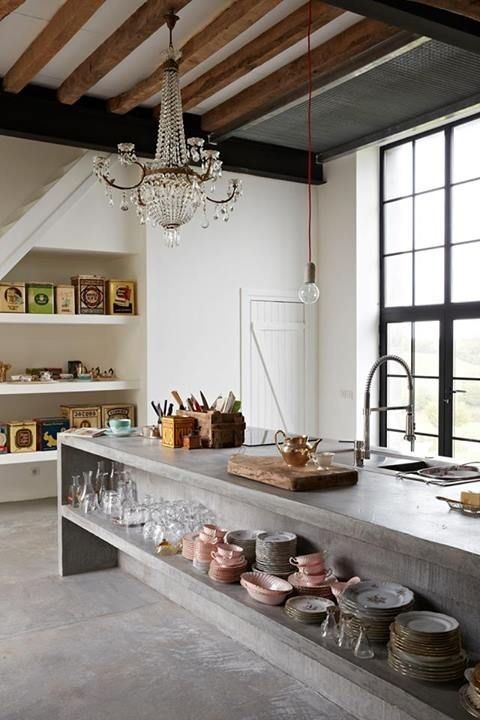 an oversized concrete kitchen islnd with open storage is a bold modern idea