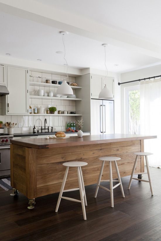 a large kitchen island clad with wood contrasts the neutral kitchen