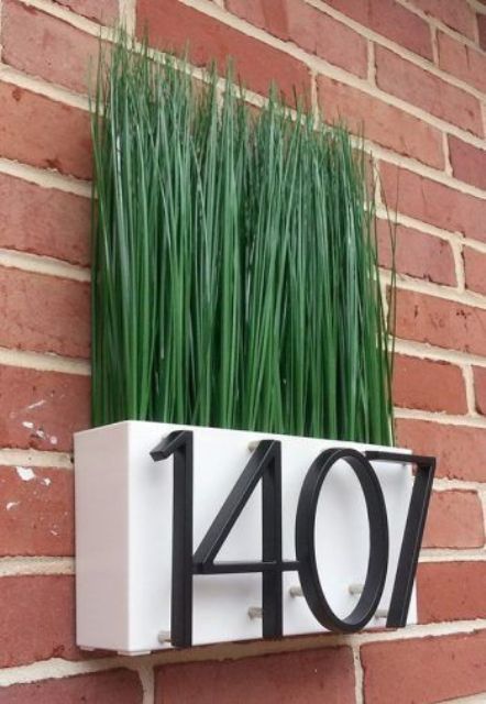 a modern house number idea with a planter with greenery (fake or not) is a cool way to refresh your outdoors