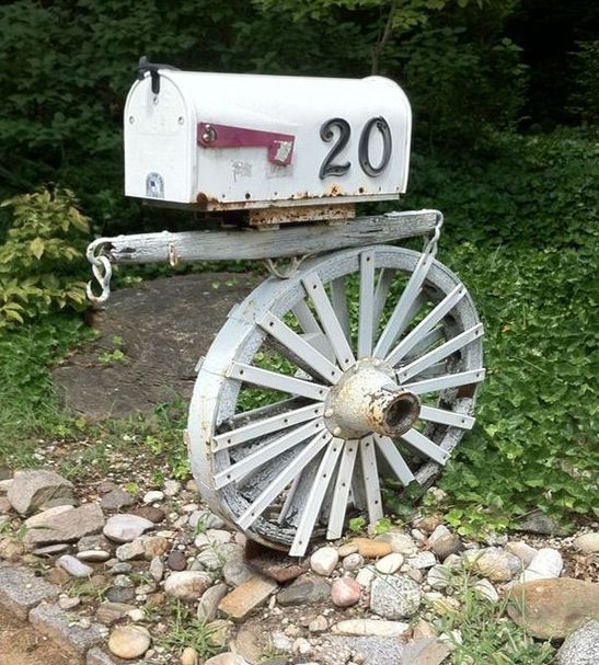 a vintage wheel and a wooden plank to hold a vintage mailbox with house numbers on it - cool for a refined touch