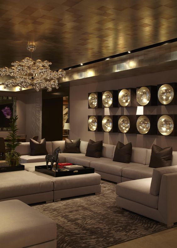 an exquisite and chic living room with a metallic ceiling, a bubble chandelier and wall lamps