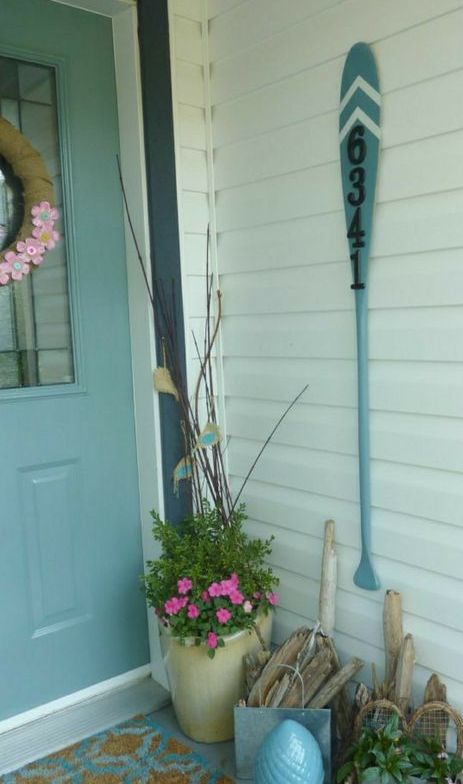 an oar with house numbers attached to the wall is a cool idea for a lake, river or beach home