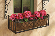 24 a black metal criss-cross window box for potted plants and flowers allows changing the plants whenever you want
