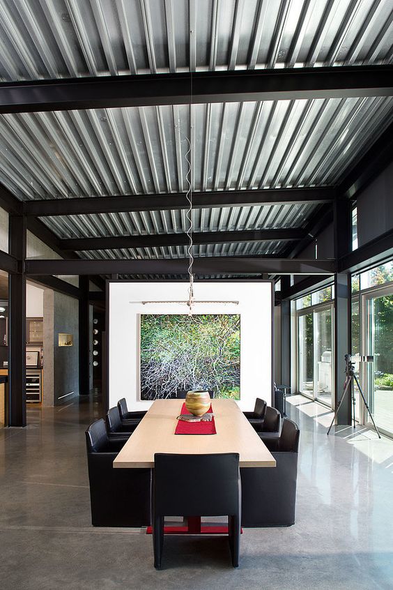 a contemporary dining room with a corrugated steel ceiling that makes the space less formal