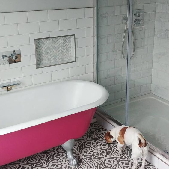 a fuchsia-colored clawfoot free-standing bathtub brings color and a vibrant touch to the space