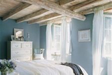 24 a vintage-inspired bedroom with a rough and rustic wooden ceiling with lots of beams that takes over the space