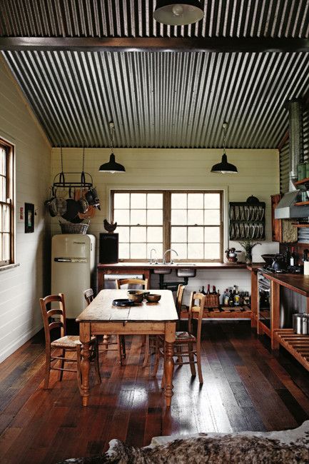 a corrugated steel ceiling with metal beams is a great idea for a sloped roof in your kitchen