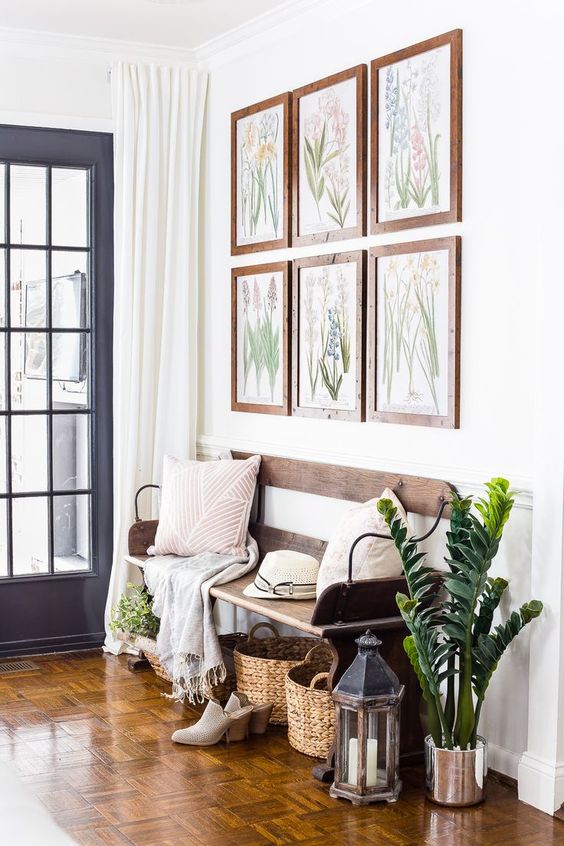 a gallery wall with botanical artworks, potted greenery, lanterns and baskets to accessorize the space