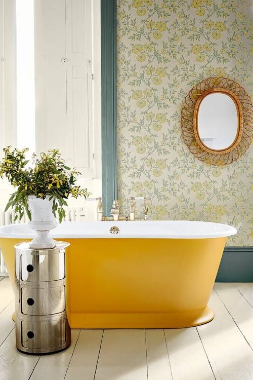 an oval yellow bathtub brigns color to the space, and makes a statement in this bathroom