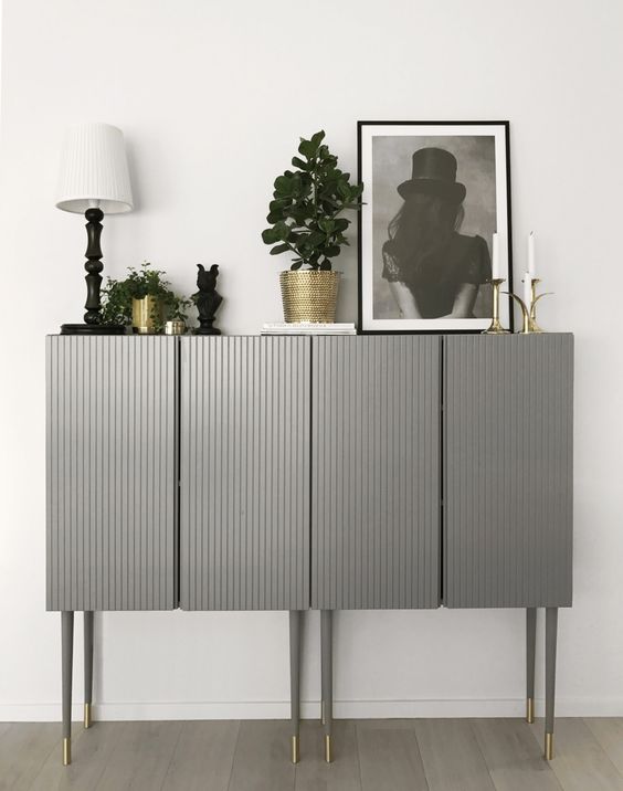 two IKEA Ivar cabinets done in grey with paneling and placed on tall legs look very chic and elegant