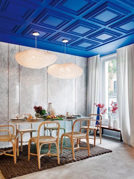 An electric blue paneled ceiling is a major color statement and design feature of the dining room
