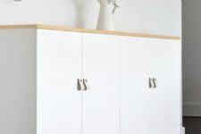 26 white Ivar cabinets with a wooden top and wooden legs plus white leather pulls look Scandinavian