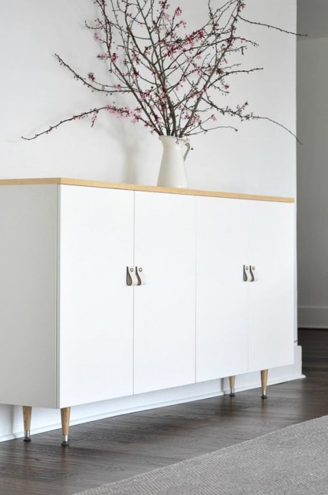 white Ivar cabinets with a wooden top and wooden legs plus white leather pulls look Scandinavian