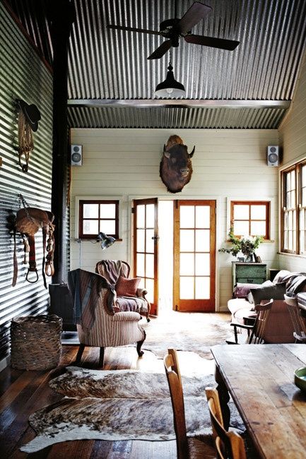 an entryway of a rustic hut with a corrugated steel ceiling and a matching wall for a rustic feel