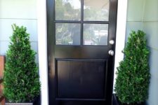 02 a black door and matching black ceramic planters with boxwood make a cool modern setup