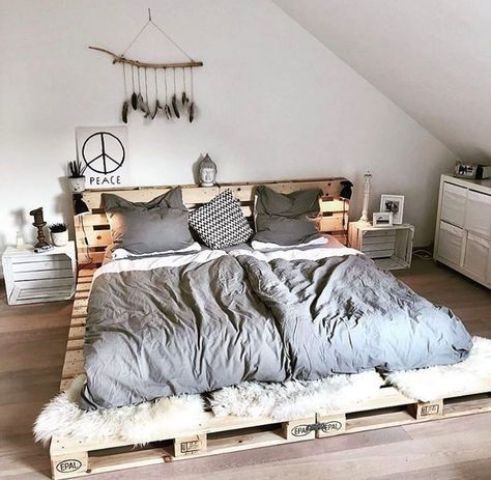 a simple low pallet bed with a headboard, with faux fur at the foot and crate nightstands for a match