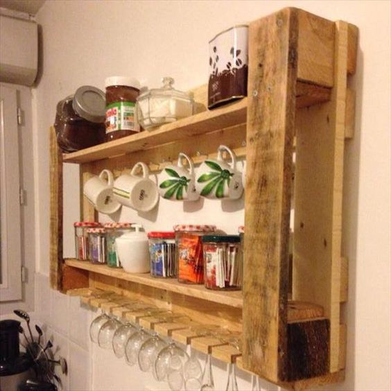 a recycled pallet rack for a kitchen features glass and mug storage and jars with various stuff