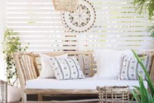 03 a welcoming tropical patio with a rustic wooden bench with pillows, a wicker lamp, a woven ottoman and a rattan candle holder