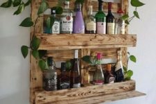 04 a stained wine rack of pallet wood features enough space for bottles and potted greenery on top
