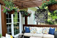 04 a super bright summer deck with ble, yellow and pink highlights, potted blooms hanging down and bright rugs