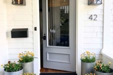 05 galvanized planters with the same bright blooms give a rustic and cozy feel to the porch