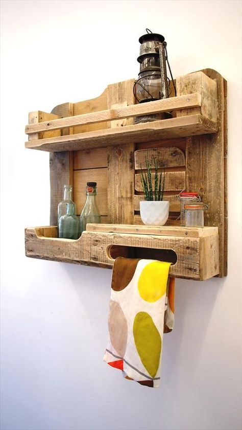 a rustic pallet kitchen shelf with a lantern, jars and bottles and even a towel holder is a cool piece