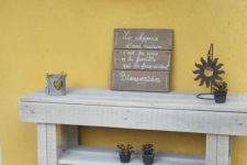 06 a simple sleek console table of pallet wood painted grey features two shelves for storage