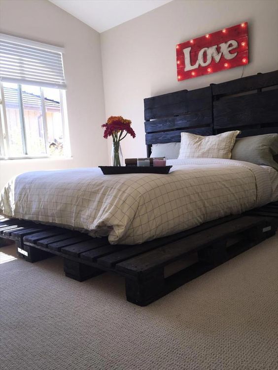 a dark painted pallet bed looks unusual and more harsh than a usual light stained one