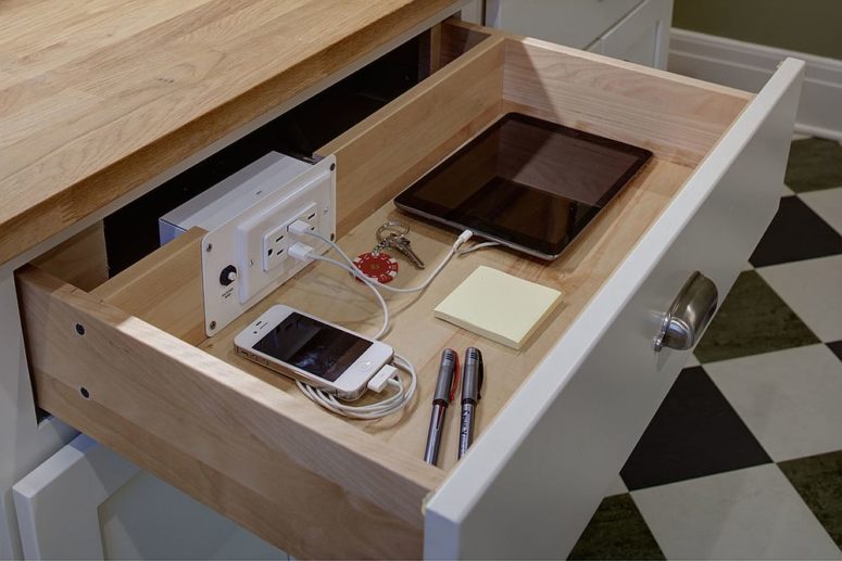 a drawer in one of the cabinets used as a charging station is a cool idea for a modern kitchen