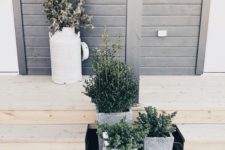 07 stylish concrete planters with greenery and a milk churn with some branches for a modern front yard