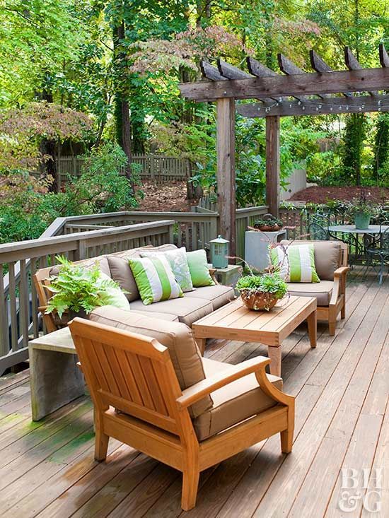 a cozy and welcoming summer deck with bright green and white touches and striped pillows for catchiness