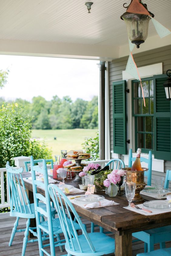 mismatching blue chairs make the outdoor dining space bold and color-infused, refresh this zone