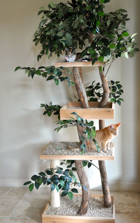 A nature inspired cat tree of branches, fake greenery and platforms with pebbles to make the cats feel like outdoors