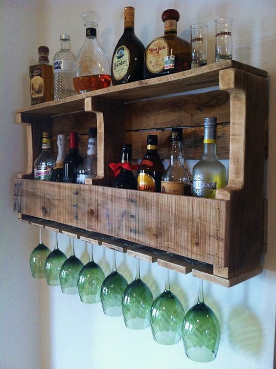 a rustic pallet wine rack with wine bottles and liquors and storage for glasses is a cool and simple DIY