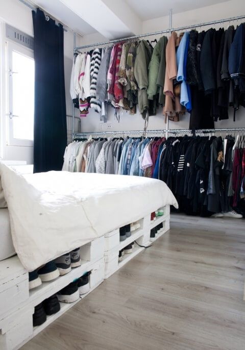 a pallet bed with storage space inside can be used to place your shoes inside - a cool idea to save some space in your bedroom