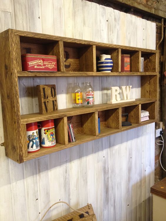 a rustic shelving unit with many compartments built of stained pallet wood is a cool DIY