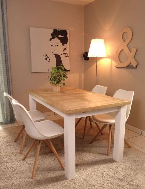 A simple indoor outdoor dining table with a tabletop made of pallet wood and a white base plus white chairs