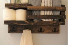 11 a rustic stained pallet shelf for a small bathroom features toilet paper storage, towel storage and even hooks for towels